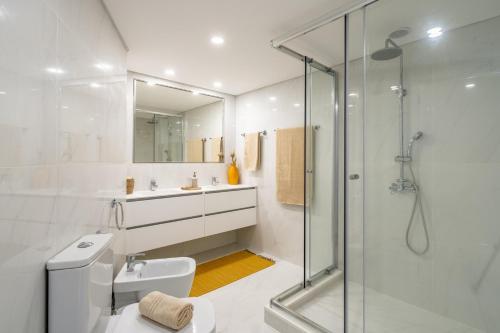 a bathroom with a glass shower and a toilet at Stay In St. Catarina Park, by PAUSA H. Rentals in Funchal