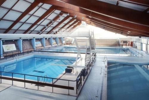 a large swimming pool in a building with at 30 minutes du Parc Floral - Suite privative in Champigny-sur-Marne