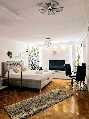 a bedroom with a bed and a flat screen tv at Deluxe Jade Apartmens in Niš