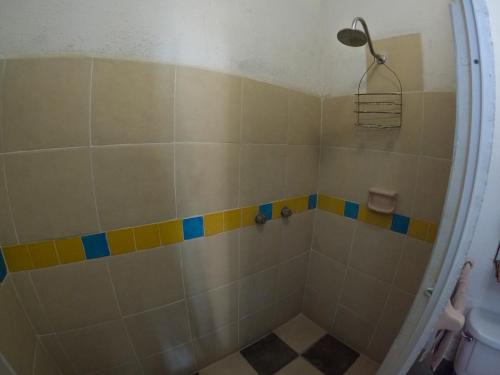 a bathroom with a shower with yellow and blue tiles at Casa Artista in Manzanillo
