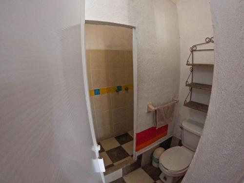 a small bathroom with a toilet and a shower at Casa Artista in Manzanillo
