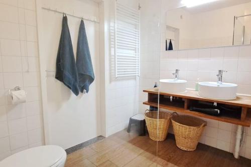 a bathroom with two sinks and a toilet at Villa Present - Vakantiewoning Kamperland VP054 in Kamperland