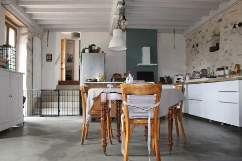 une cuisine avec une table et des chaises dans une pièce dans l'établissement Grande maison familiale, à Ganac