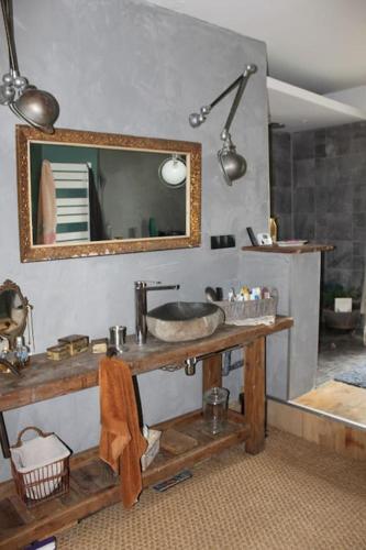 une salle de bain avec un lavabo et un miroir dans l'établissement Grande maison familiale, à Ganac