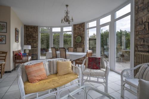 un salon avec des chaises, une table et des fenêtres dans l'établissement Magnifique Villa plage à 20m, à Saint-Cyr-sur-Mer
