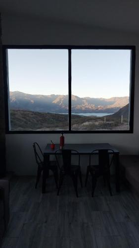 a room with a table and chairs and a large window at Casa MoodSpot Potrerrillos vistas 360 in Cacheuta
