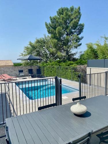 une table avec un chapeau en haut, à côté d'une piscine dans l'établissement La Maison du Sud, à La Bastide-dʼEngras