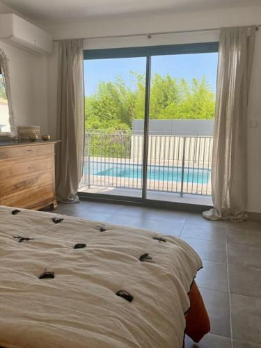 une chambre avec un lit et une grande fenêtre dans l'établissement La Maison du Sud, à La Bastide-dʼEngras