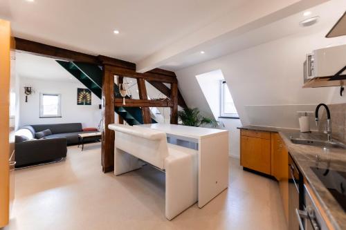 - une cuisine avec un îlot blanc dans une chambre dans l'établissement Le nid de cigogne - Rouffach, à Rouffach