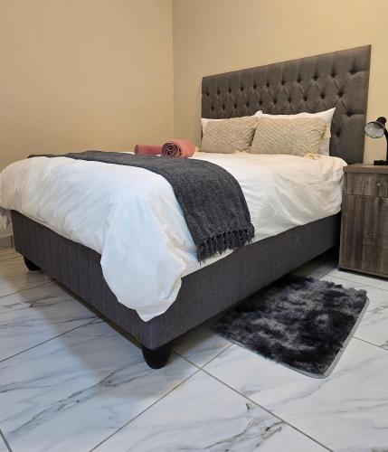 a bedroom with a large bed and a rug at 55 New Street, Makhanda in Grahamstown