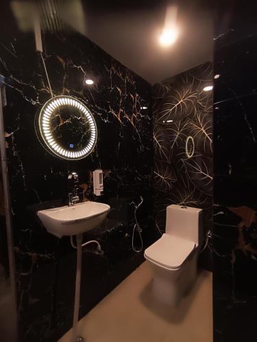 a black bathroom with a toilet and a sink at Sukoon River Homestay in Varanasi