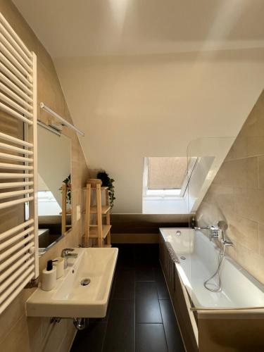 un baño con lavabo y bañera en DOWA Apartments, en Viena