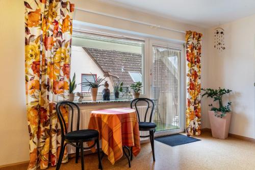 a dining room with a table and chairs and a window at Haus Ursula in Ettenheim