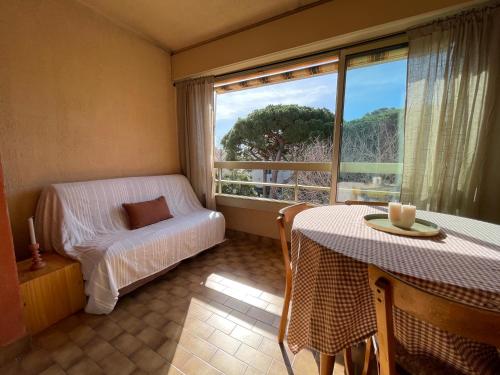 une pièce avec une table, une chaise et une fenêtre dans l'établissement Appartement cosy sur le port proche des plages, à Hyères