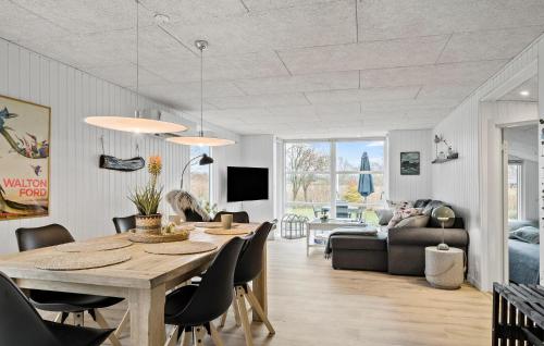 a dining room and living room with a table and chairs at Cozy Home In Haderslev With Wifi in Haderslev