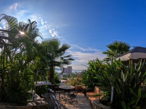 a patio with a table and chairs and plants at Casa Artista in Manzanillo