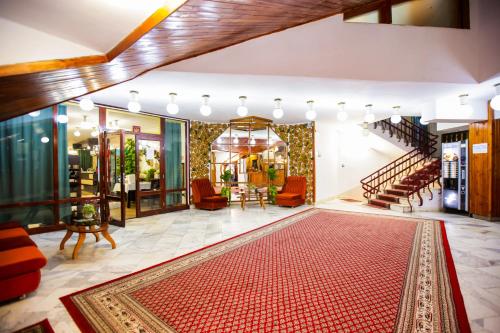 a lobby with stairs and a red rug at Почивна станция - ТЕЦ Бобов дол in Bistriza