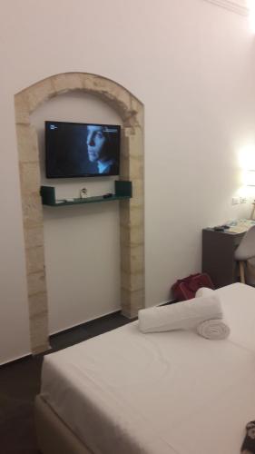 a hotel room with a bed and a flat screen tv at Villa Gatto Alice in Rometta Marea