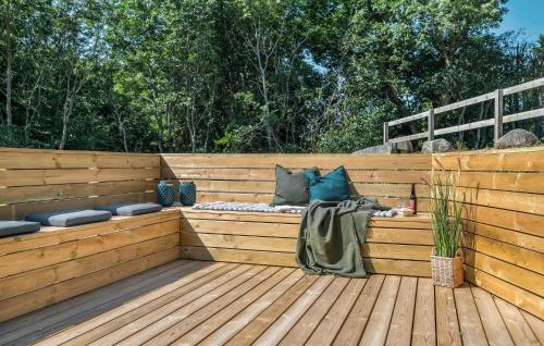 a wooden deck with a bench with pillows at Holiday Home Ristingevej Humble Ii in Humble