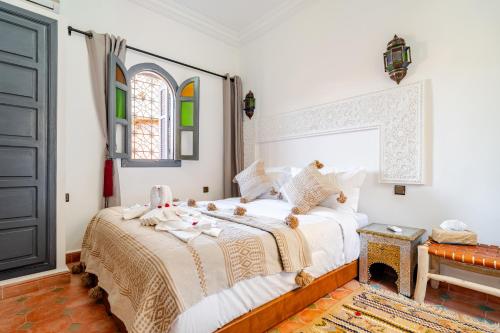 a bedroom with a bed with white sheets and a window at Riad La Kasbah secrète in Marrakech