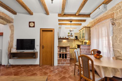 a kitchen and dining room with a table and a television at Alba Sanja i Teran in Funtana