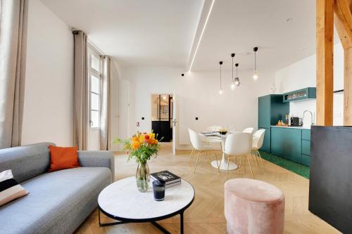 un salon avec un canapé et une table dans l'établissement SERENERS - Charming Serviced Apartments - Place des Vosges, à Paris