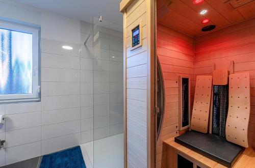 a bathroom with red and white walls and a window at Merlin Nest - Komfortable Wohnung mit Terrasse, Garten & Infrarotkabine in Marienfelde