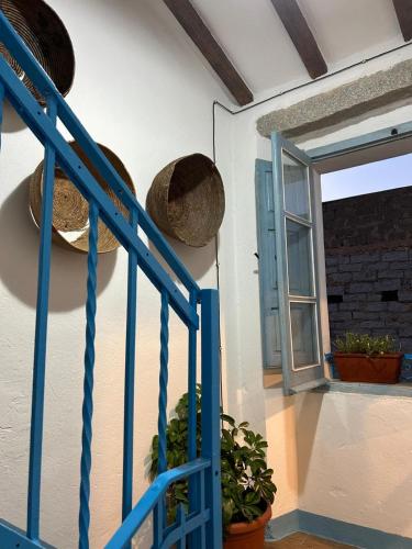 a room with a blue ladder and baskets on the wall at B&B su Ponte in Orgosolo