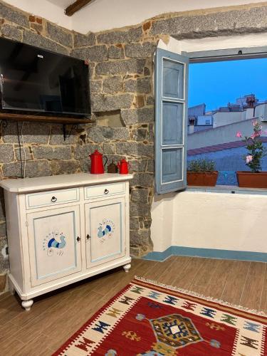 a living room with a white cabinet and a window at B&B su Ponte in Orgosolo