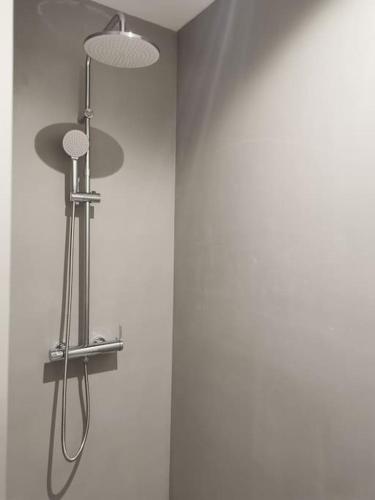 une douche avec deux lumières sur un mur dans l'établissement charmant appartement au cœur du village, à Claret