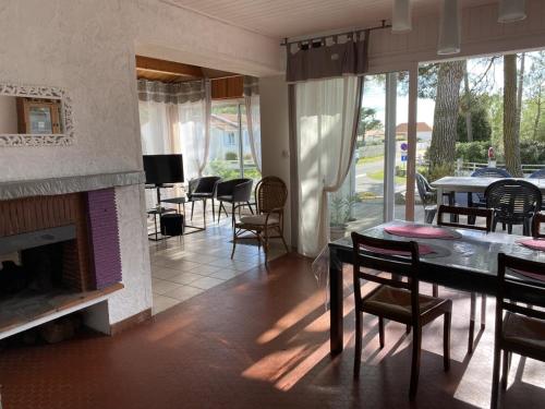 - un salon avec une cheminée, une table et des chaises dans l'établissement Ma Briane - Plage à 150 m, à La Tranche-sur-Mer