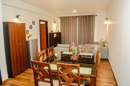 ヌワラエリヤにあるLake Side Haven Apartmentのソファとテーブルと椅子のあるリビングルーム