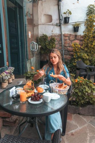 a woman sitting at a table eating food at Rumi's Inn in Cusco