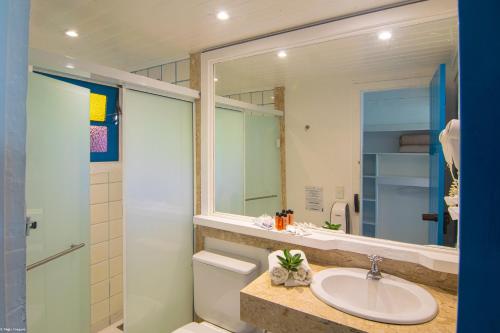 a bathroom with a sink and a mirror at Chez Pitu Praia Hotel in Búzios