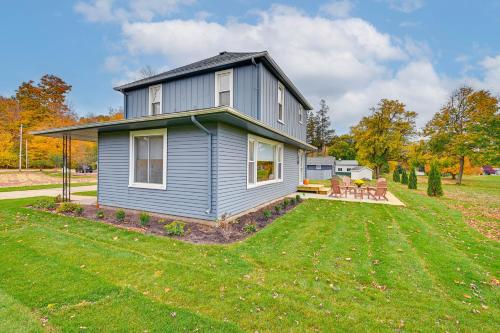 a blue house on a lawn with a picnic table at Home on Legacy Hills Golf Course with Patio! in LaPorte