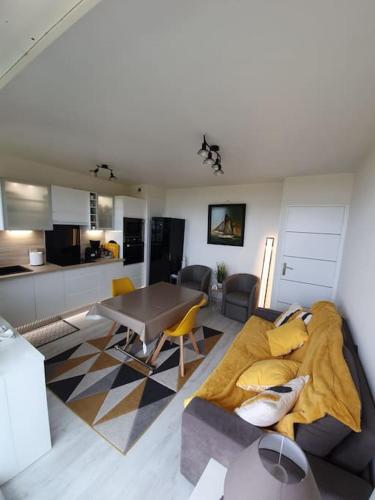 un salon avec un canapé et une table dans l'établissement Cap au Large-Vue Mer Panoramique, à Cabourg