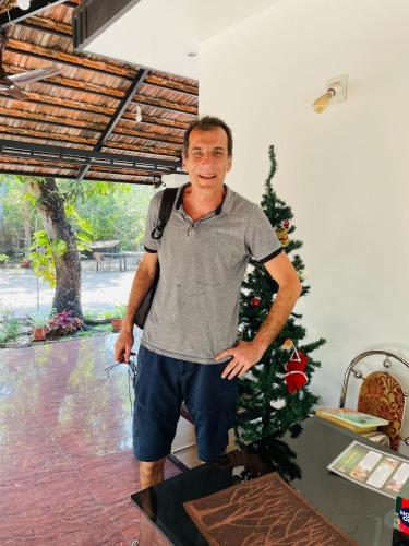 a man with a backpack standing next to a christmas tree at SALT LIFE MARARI BEACH VILLA in Mararikulam