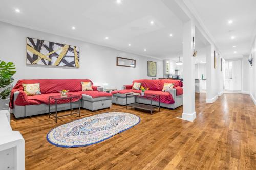a living room with red couches and a rug at Amazing 3-Bedrooms in Rosemont - Montreal in Montréal