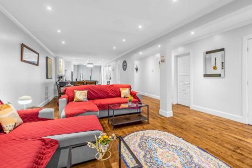 a living room with red couches and a table at Amazing 3-Bedrooms in Rosemont - Montreal in Montréal