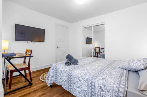 a bedroom with a bed and a desk and a tv at Amazing 3-Bedrooms in Rosemont - Montreal in Montréal