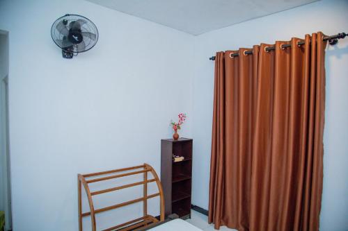 a room with a curtain and a fan and a shelf at Shiny Villa in Unawatuna