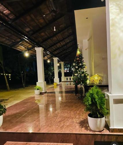 a lobby with a christmas tree in the middle of a building at SALT LIFE MARARI BEACH VILLA in Mararikulam