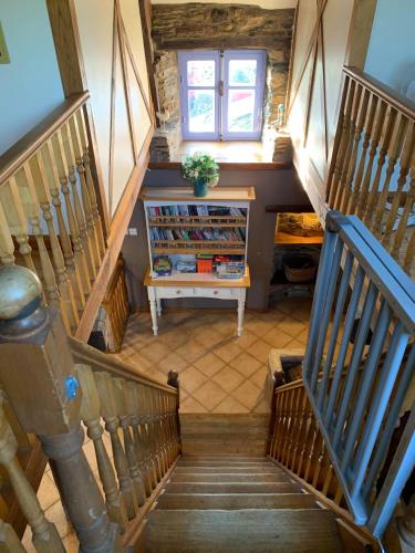 a staircase with a book shelf in a house at Clipgites in Pleugriffet