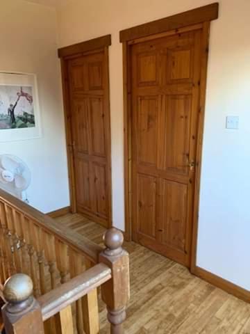 a room with two wooden doors and a staircase at Clipgites in Pleugriffet