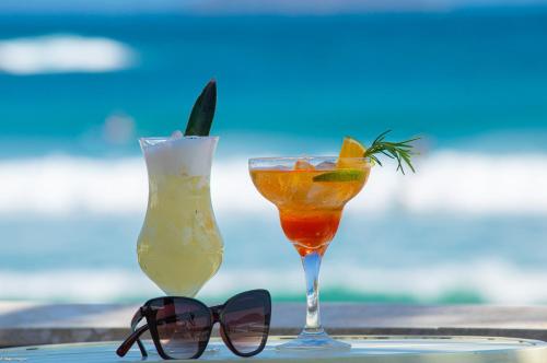 two cocktails sitting on a table next to sunglasses at Chez Pitu Praia Hotel in Búzios