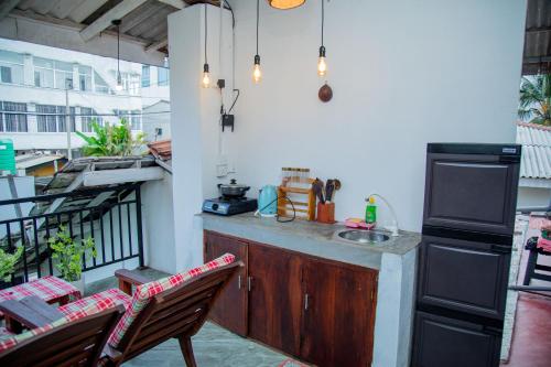 a kitchen with a sink and two chairs on a balcony at Shiny Villa in Unawatuna