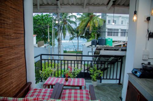 a balcony with a table and a view of the ocean at Shiny Villa in Unawatuna