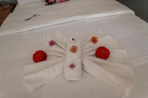 a bed with white towels with flowers on it at La Vatura in Gialova