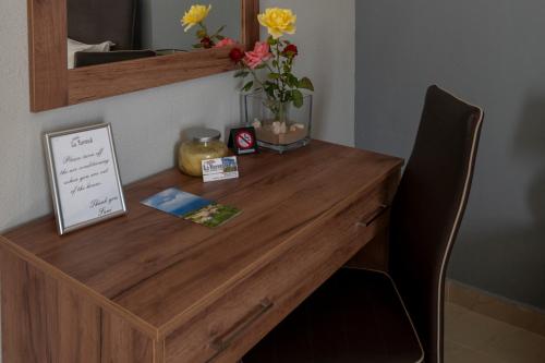 a wooden desk with a vase of flowers on it at La Vatura in Gialova