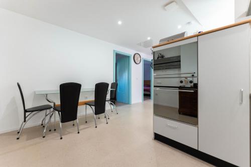 une cuisine et une salle à manger avec une table et des chaises dans l'établissement Le grenier des hirondelles - Rouffach, à Rouffach